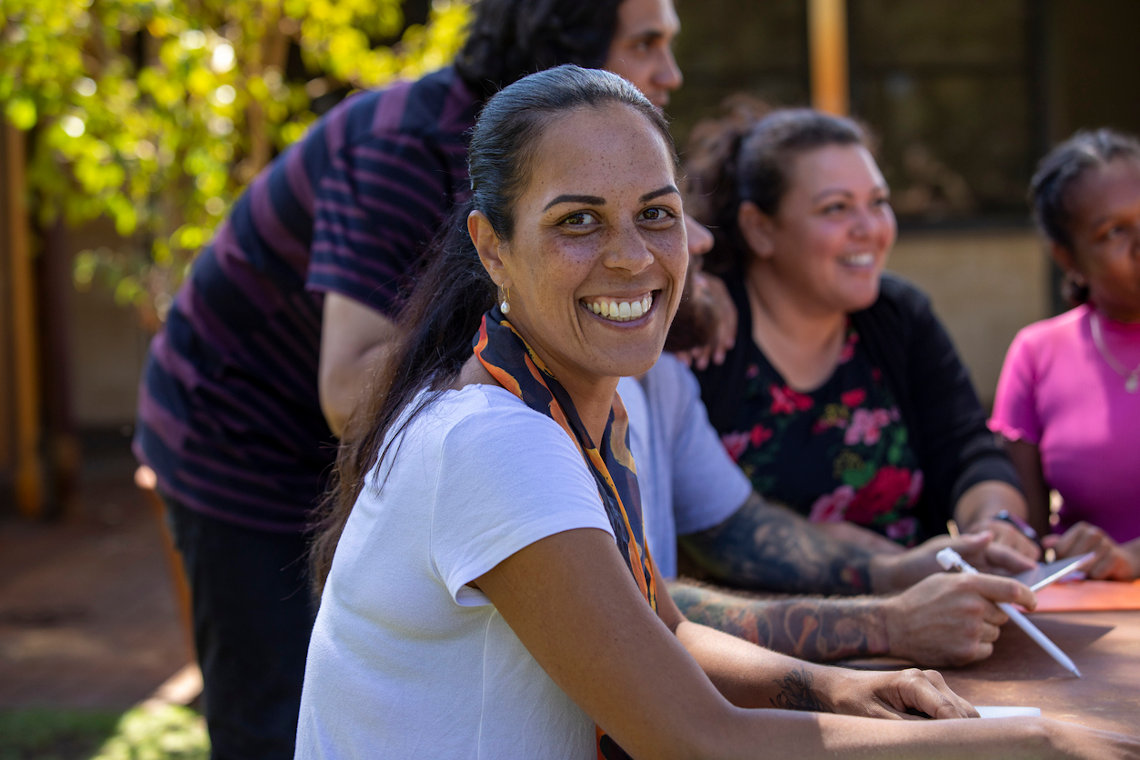 Indigenous trainer outside with course participants.